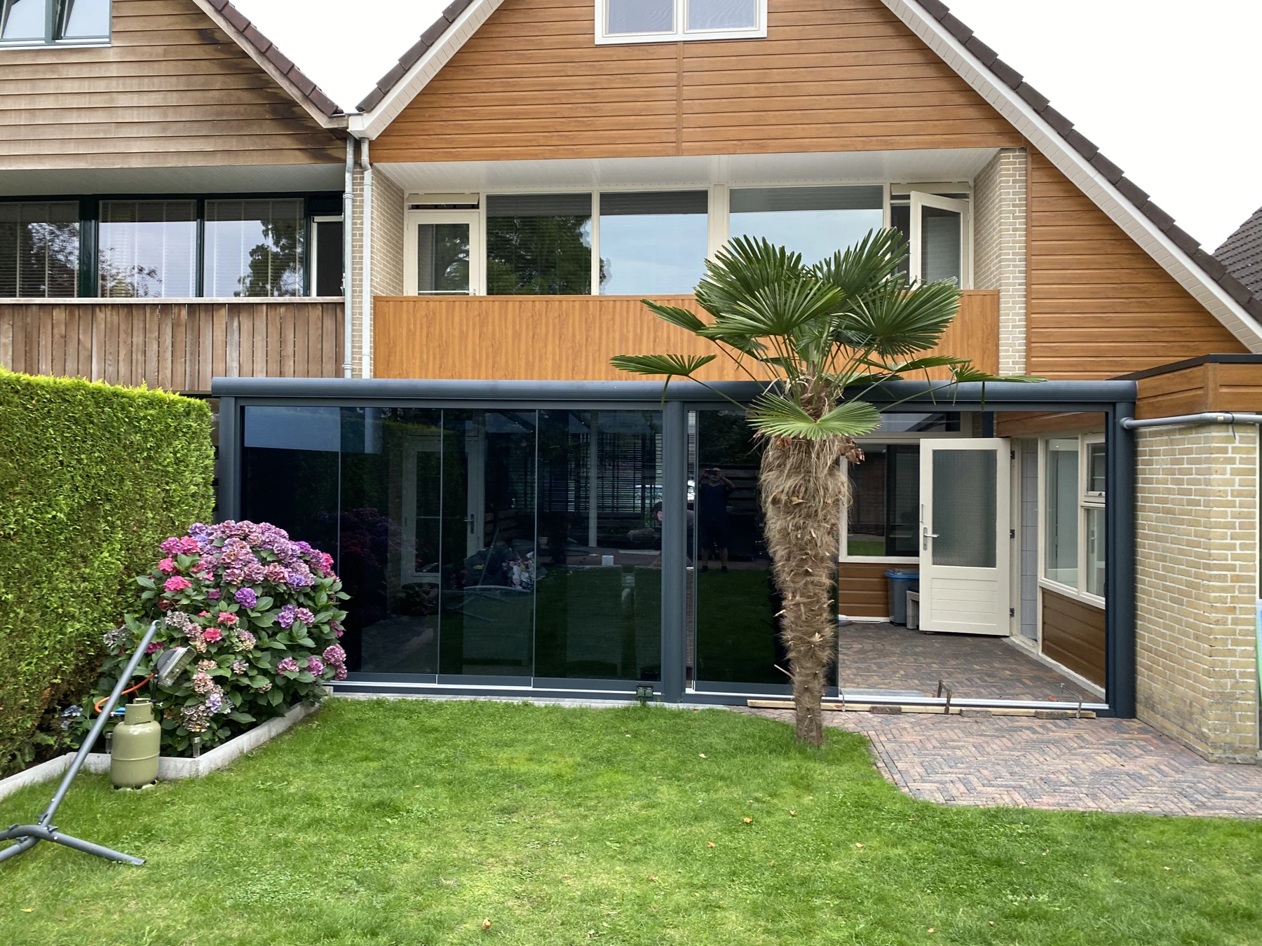 Het terras met veranda en glazen schuifwanden